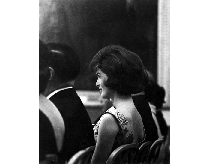 ST-45-5-61                                           13 March 1961  Reception for Latin American Diplomats, Officials, and Members of Congress. Profile shot of First Lady Jacqueline Kennedy sitting in the audience. East Room, White House, Washington, D.C.  Cecil Stoughton. White House Photographs. John F. Kennedy Presidential Library, Boston