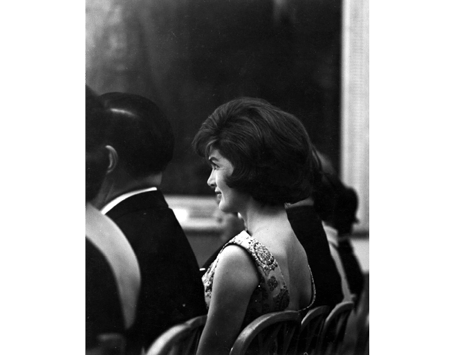 ST-45-5-61                                           13 March 1961  Reception for Latin American Diplomats, Officials, and Members of Congress. Profile shot of First Lady Jacqueline Kennedy sitting in the audience. East Room, White House, Washington, D.C.  Cecil Stoughton. White House Photographs. John F. Kennedy Presidential Library, Boston