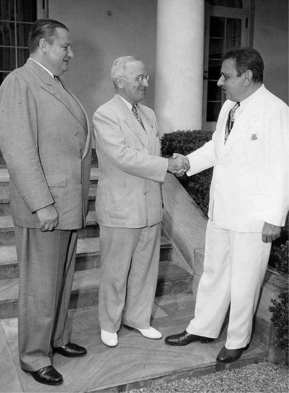 Photo of Puerto Rico's first elected Governor, Luis Munoz Marin (right), being greeted by President Harry S. Truman at the White House. On the left is Secretary of the Interior J.A. Krug. From: Beth Gore.