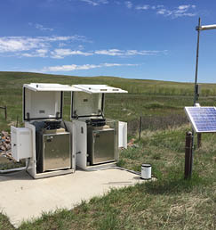 Two white appliances are sitting on a concrete slab in a grassy field. AI generated content