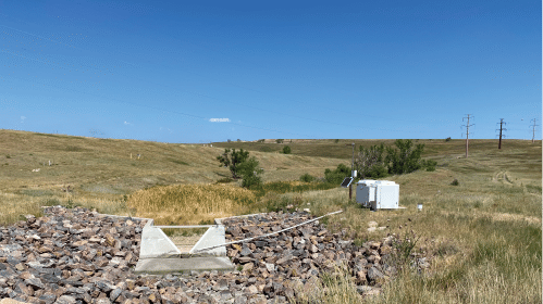 A man is standing in a field with a white trailer. AI generated content