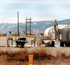 A group of people wearing protective gear are standing next to a truck. AI generated content