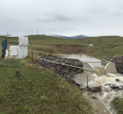 A man is standing next to a white object in a field. AI generated content