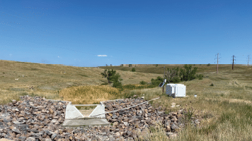 A man is standing in a field with a white trailer. AI generated content