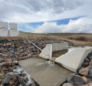 A concrete ramp leads to a water source, with a truck parked nearby. AI generated content